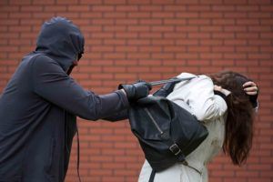 Maskierter greift nach einer Handtasche