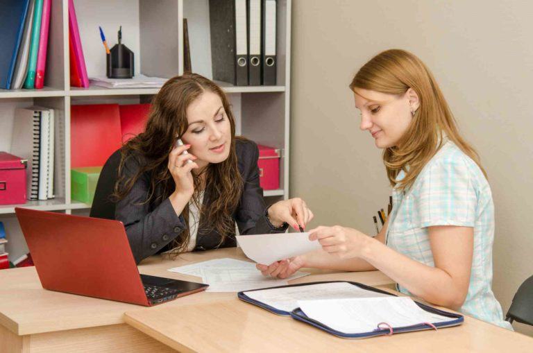 Zwei Frauen diskutieren beim Schreibtisch
