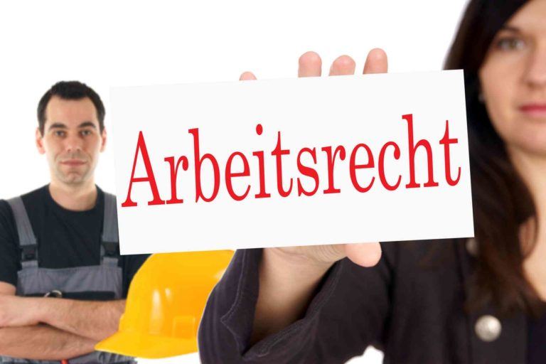 Frau hält Tafel mit Arbeitsrecht in der Hand. Im Hintergrund steht ein Arbeiter