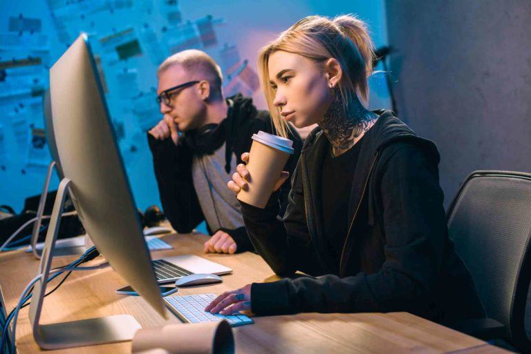 Mitarbeiterin und Mitarbeiter sitzen vorm Computer und Arbeiten