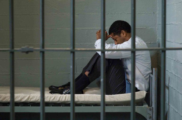 Mann sitzt im Haft hinter Gittern und wird eine Ersatzfreiheitsstrafe abgeleistet