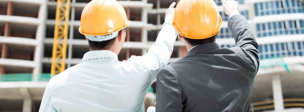 Zwei Männer zeigen auf Baustelle