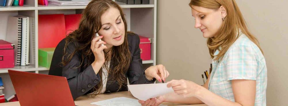 Zwei Frauen diskutieren beim Schreibtisch